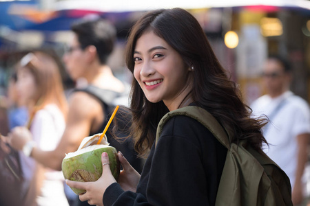 有吸引力的年轻妇女的画像饮用椰子 ju