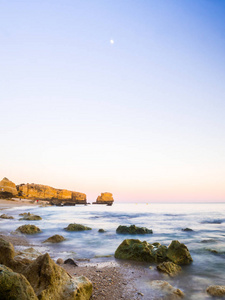 美丽的洛基圣拉斐尔海滩在日落时间与干净的蓝色水在阿尔加维地区, 葡萄牙