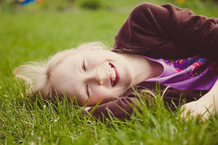 女孩躺在绿色的草地上笑着笑着