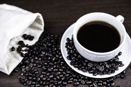 黑咖啡杯和咖啡豆的木材背景