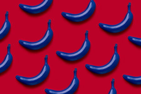 红色背景的新鲜蓝色香蕉的五颜六色的果子样式。从顶部视图