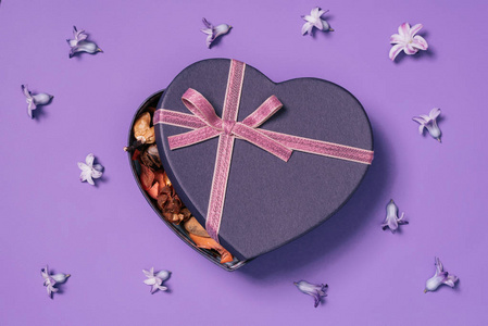 心形礼品盒顶部的花周围紫色隔离