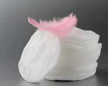 棉花化妆品磁盘海绵与粉红色的羽毛