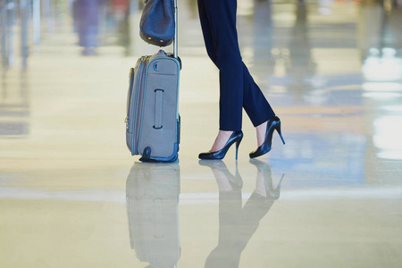 优雅的商务妇女与手提行李在国际机场航站楼。机舱船员与手提箱。无法辨认的人, 腿和高跟鞋的特写