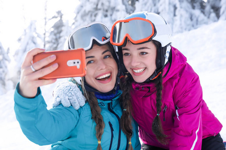 在滑雪山度假胜地自拍的年轻妇女。寒假