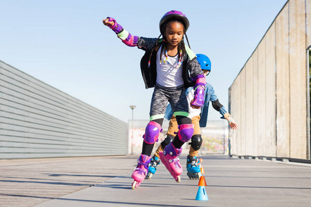 青春期非洲女孩学习在户外 skatepark 溜冰鞋溜冰滑雪