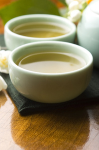 绿茶与茉莉花在杯子和木桌上的茶壶