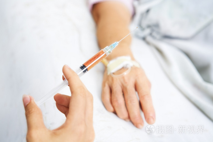 在背景上拿注射用病人的手的手