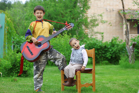 两个有趣的男孩子学音乐的学生演唱 演奏吉他 outd