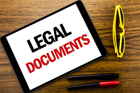 编写显示法律文件的文本。在平板电脑上写的合同文件的业务概念, 木质背景与假期黄色眼镜和标记笔