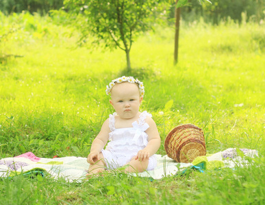 可爱的婴孩在一个花圈在野餐在夏天天