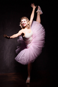 美丽适合的肖像年轻的芭蕾舞女演员粉红色休闲和芭蕾舞服装在工作室摆姿势