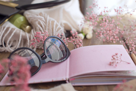 太阳镜和粉红色笔记本, 干净的床单。规划。复制空间