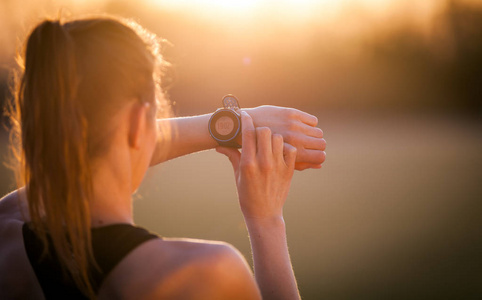 健身妇女设置智能手表前运行训练日落