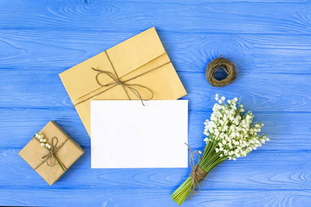 春季蓝色背景。鲜花, 信封, 包装礼品, 贺卡。平躺, 顶部视图