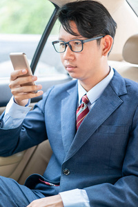 年轻的亚洲商务男士肖像在汽车上谈论电话