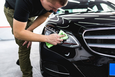 一个男子清洁汽车与超细纤维布, 汽车详细 或 valeting 概念。选择性聚焦