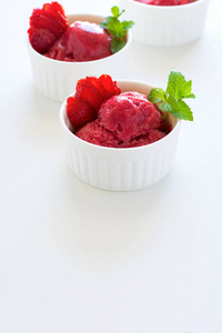水果草莓冰淇淋与薄荷在碗上白色木质背景
