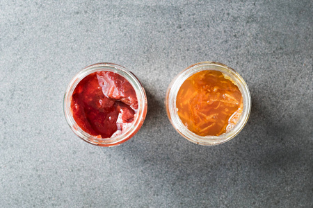 有机橙接骨和草莓果酱在罐子各种果酱。早餐食品