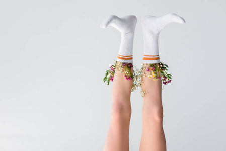 女性腿与花在灰色的袜子上的倒置视图