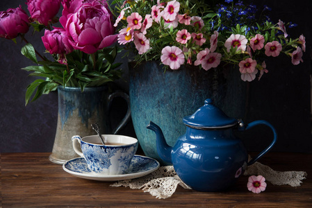 美丽的花朵在花瓶和杯茶在木桌, 夏季装饰
