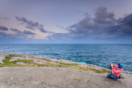 女摄影师拍照相机上 Lindesnes，南角背心阿格德，挪威挪威的最南点