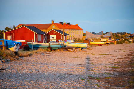 在瑞典日落灯光下的石质海滩钓鱼船和捕鱼