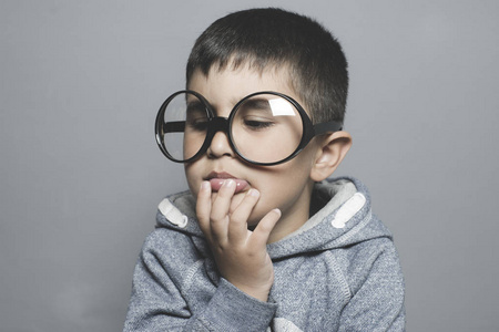 思考, 戴着大眼镜的男孩非常严肃和思考