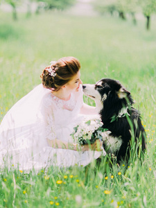 在草地上的狗坐在旁边的花束新娘的垂直肖像