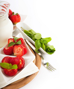 草莓与薄荷和水罐的牛奶在一块白色餐巾来。