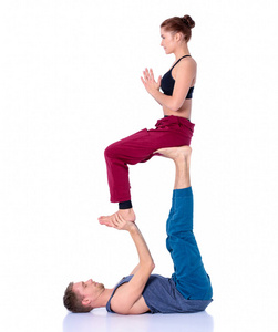 年轻的体育夫妇练习 acroyoga。双平衡