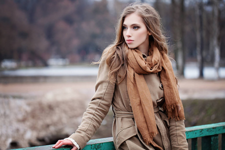 美丽的时尚女人在棕色围巾户外