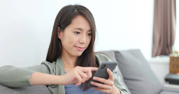 年轻女子在家中使用的智能手机