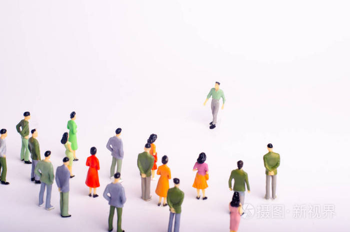 人群正在看着那个在白色背景下朝她走来的人.这个人正在接近一群人.
