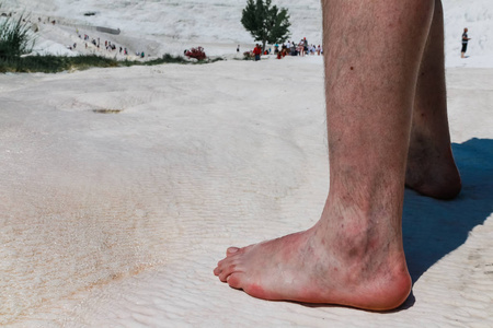 男人的脚上的白色石灰岩的棉花在一个晴朗的日子里, 土耳其