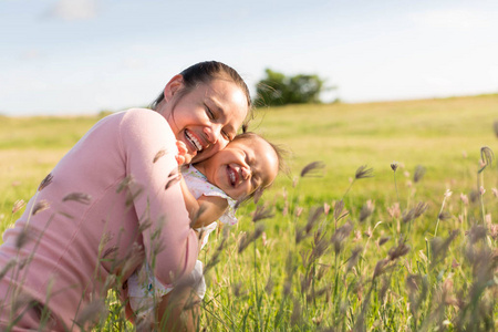 年轻的女孩和 1 哟宝贝在荒草丛生的原野中拥抱