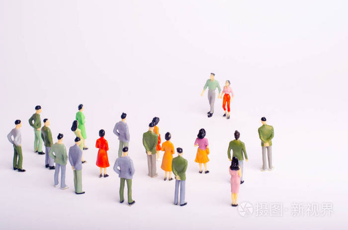 人群看着在白色背景下向她走来的男人和女人.