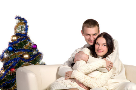 在一个白色的沙发的圣诞树夫妇