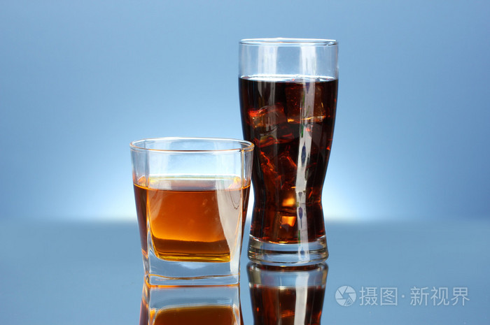 杯威士忌和一杯可乐上蓝色背景特写