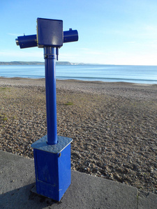 传统的硬币操作蓝色公共望远镜看着横跨韦茅斯海滩和海湾在赛特, 英国