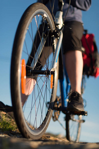 在日出的路上, 骑山地自行车的骑车人的低角度观看。体育和活跃生活概念