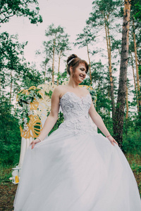 美丽的女人在婚纱礼服上的 photozone 装饰鲜花, 摆姿势和肖像