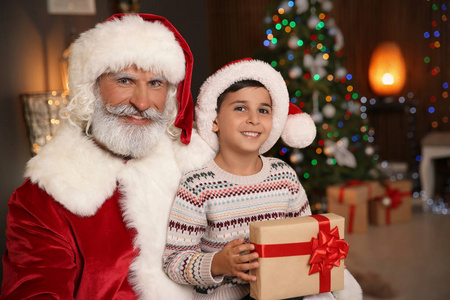 小孩子与圣诞老人和圣诞节礼物在家
