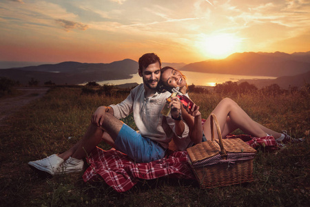 年轻夫妇有愉快的时间在日落在博卡湾野餐