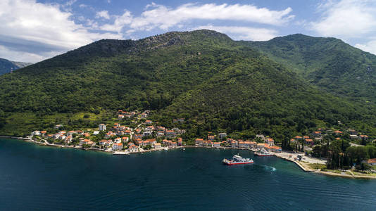 从上到 Kotor 湾和定期客运渡轮从 Lepetane 到 Kamenari 的空中美景, 阳光明媚的下午