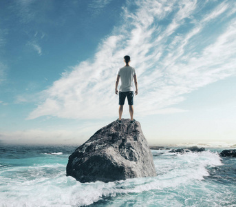 人站在岩石的海洋中间。风险与研究理念