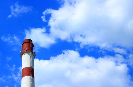 工业景观与锅炉管与红色和白色条纹反对在多云的蓝天背景与复制空间。阳光明媚的天气中锅炉管道的云