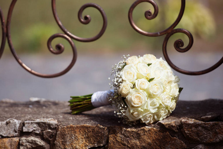 婚礼花束。躺在石头上的白玫瑰