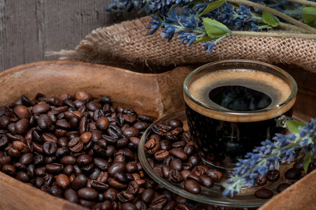咖啡豆和一杯浓咖啡在一个木托盘上的心脏形式