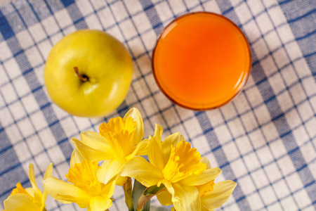 黄色的水仙花和苹果的花束, 橙汁的玻璃